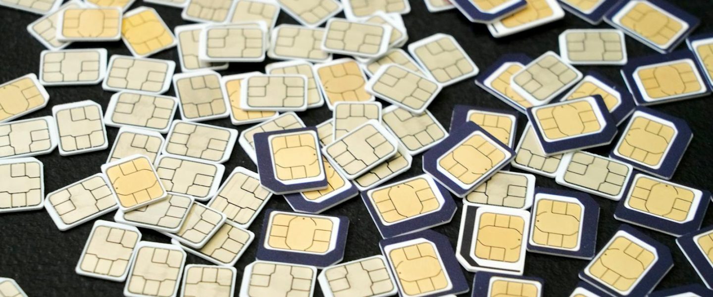 Multiple SIM cards scattered on a black surface, showcasing the complexity of cellular technology.